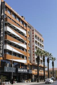 a hotel with palm trees in front of a building at Alican 1 Hotel in Izmir