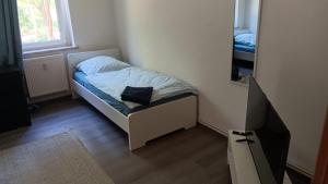 a small bed in a small room with a mirror at Crew Quartier ALL-INCLUSIVE Serviced Apartments ideal für Monteure 3 Schlafzimmer in Merseburg