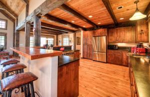 a kitchen with wooden cabinets and a kitchen island with bar stools at Antler Ridge Lodge in Big Sky