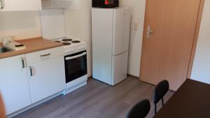 a kitchen with a white refrigerator and a table and chairs at Crew Quartier ALL-INCLUSIVE Serviced Apartments ideal für Monteure 3 Schlafzimmer in Merseburg