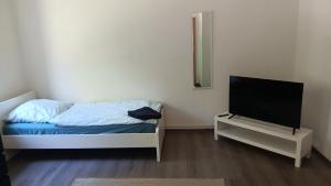 a small bedroom with a bed and a tv at Crew Quartier ALL-INCLUSIVE Serviced Apartments ideal für Monteure 3 Schlafzimmer in Merseburg