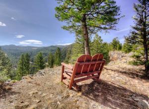a wooden bench sitting on top of a hill at Antler Ridge Lodge in Big Sky