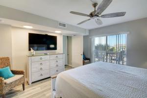 a bedroom with a bed and a flat screen tv at El Matador 430 - Third floor unit in Fort Walton Beach