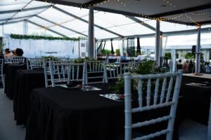 een groep tafels met zwarte tafelkleden en witte stoelen bij Hotel Laimoa in Apia
