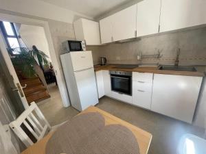 a small kitchen with white cabinets and a table with a heart at Vistas al mar, montaña y volcán in El Paso