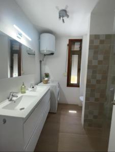 a white bathroom with two sinks and a shower at Vistas al mar, montaña y volcán in El Paso