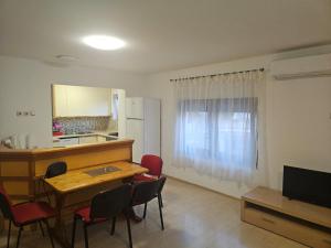 a living room with a table and chairs and a kitchen at Apartman Dinja in Posušje
