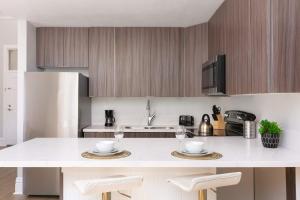 eine Küche mit einer weißen Theke und Holzschränken in der Unterkunft Gaslamp Loft Escape Sleeps 7 in Style in San Diego + 20 Fotos