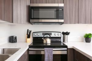 eine Küche mit Herd und Wasserkocher in der Unterkunft Gaslamp Loft Escape Sleeps 7 in Style in San Diego