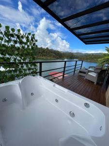 een wit bad bovenop een terras bij Boreal Glamping in Guatapé