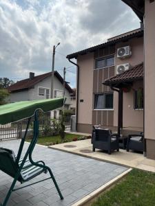 a green chair sitting on a patio in a yard at Apartman Harmonija in Bajina Bašta
