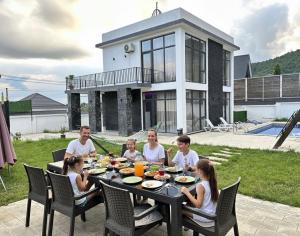 a family sitting at a table eating dinner at Qafqaz Mandarin Deluxe in Gabala