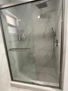 een douche met een glazen deur in een badkamer bij 海湾景观休闲独立屋可垂钓靠近达利博物馆 in St Petersburg