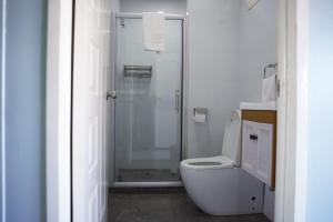 een witte badkamer met een douche en een toilet bij Hotel Laimoa in Apia