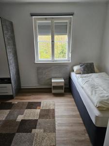 ein Schlafzimmer mit einem Bett und einem Fenster in der Unterkunft Monteurwohnungen bei Rothenburg odT in Rothenburg ob der Tauber + 15 Fotos