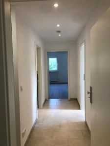 ein leerer Flur eines Hauses mit einer Tür und einem Fenster in der Unterkunft Monteurwohnungen bei Rothenburg odT in Rothenburg ob der Tauber