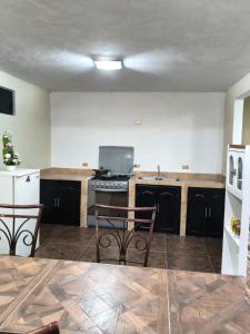 an empty kitchen with two chairs and a stove at Finca Chapis in San Sebastian Xolalpa