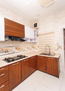 a kitchen with wooden cabinets and a sink at Tranquil 5BR Duplex in Lekki in Maiyegun