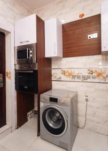 a kitchen with a washing machine and a microwave at Tranquil 5BR Duplex in Lekki in Maiyegun