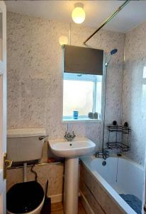 a bathroom with a sink and a toilet and a tub at Sir Isaac Newton in Lincolnshire