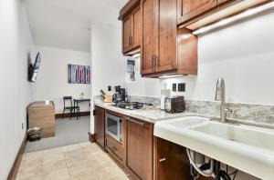 a kitchen with wooden cabinets and a sink at Arrowleaf Lodge - 1 Bed Studio #100A in Park City