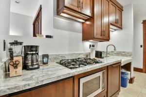 a kitchen with wooden cabinets and a stove top oven at Arrowleaf Lodge - 1 Bed Studio #100A in Park City