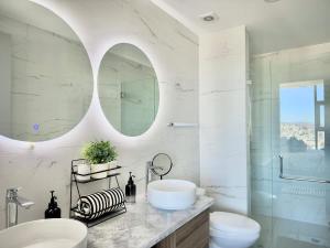 a white bathroom with two sinks and a mirror at Cosmopolitan TJ - Costco and San Ysidro Border USA in Tijuana