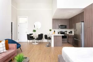Una sala de estar y una cocina con un sofá rosa. en Bright 2BR Loft Sleeps 7 with Full Kitchen and Fast WiFi, en San Diego