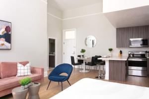 Una sala de estar y una cocina con un sofá rosa. en Bright 2BR Loft Sleeps 7 with Full Kitchen and Fast WiFi, en San Diego