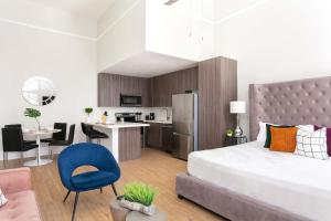 Un dormitorio con una cama grande y una cocina. en Bright 2BR Loft Sleeps 7 with Full Kitchen and Fast WiFi, en San Diego