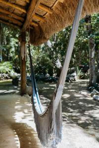 a hammock hanging from a straw roof at Cavelands become one with nature in Cedro