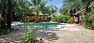 a swimming pool in front of a house at Abené shuDyma lodge in Abémé