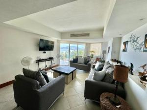 ein Wohnzimmer mit zwei Sofas und einem Fernseher in der Unterkunft Bay View Grand residencial Ixtapa in Ixtapa