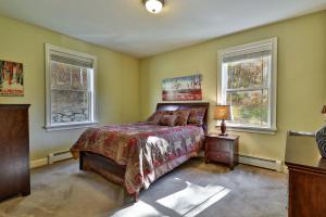 une chambre avec un lit et deux fenêtres dans l'établissement Big Boulder at Killington - Renovated Home with Hot Tub, Sauna, and Views, à Killington Village