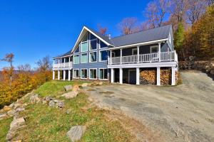 une grande maison bleue au sommet d'une colline dans l'établissement Big Boulder at Killington - Renovated Home with Hot Tub, Sauna, and Views, à Killington Village