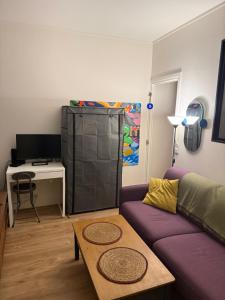 ein Wohnzimmer mit einem lila Sofa und einem Tisch in der Unterkunft Charmant appartement vue jardin in Neuilly-sur-Seine + 10 Fotos