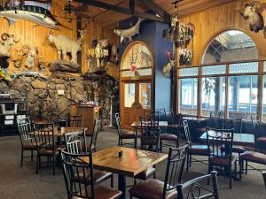 a restaurant with tables and chairs and a stone wall at Hot Springs Hotel & Spa in Thermopolis