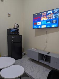 a room with two tables and a television on a wall at Masaka Haven in Masaka