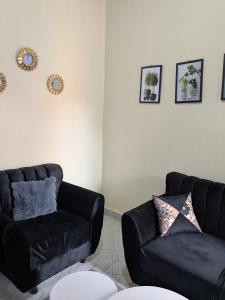 a living room with a black couch and a chair at Masaka Haven in Masaka