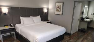 a bedroom with a large bed with white sheets at Anderson Inn in Anderson