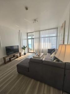 a living room with a couch and a flat screen tv at برج داماك جده شقه مطله على البحر damac jeddah in Jeddah