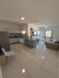 a large kitchen and living room with a couch and a table at Casa aconhegante e cheirosa in Nanuque