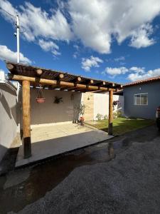 a wooden pergola in front of a house at Casa aconhegante e cheirosa in Nanuque