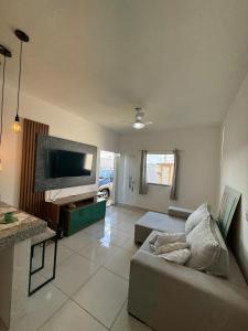 a living room with a couch and a flat screen tv at Casa aconhegante e cheirosa in Nanuque