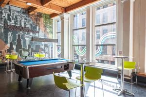 a pool table in a room with a wall of windows at HI Chicago Hostel in Chicago