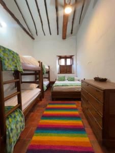 ein Zimmer mit zwei Etagenbetten und einem Teppich in der Unterkunft Habitación Isabelina 3 ó 4 personas in Barichara