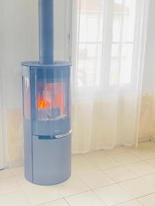 a blue heater with a fire in it in a room at Maison Individuelle Tout Confort Terrasse Extérieur Proche Parc Asterix, Aéroport Roissy CDG, Paris, Disney, Château de Chantilly in La Chapelle-en-Serval