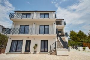 a white building with balconies on it at Villa Cherry in Rogoznica