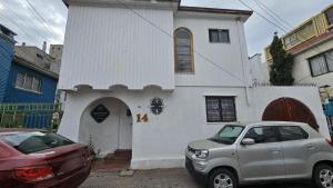 a car parked in front of a white church at Hostel Gloria Viña in Viña del Mar