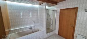 Casaba Suite -260 qm-2 floors- 7 Rooms-Free Private Parking-House with garden في هانوفر: حمام أبيض مع حوض استحمام ودش